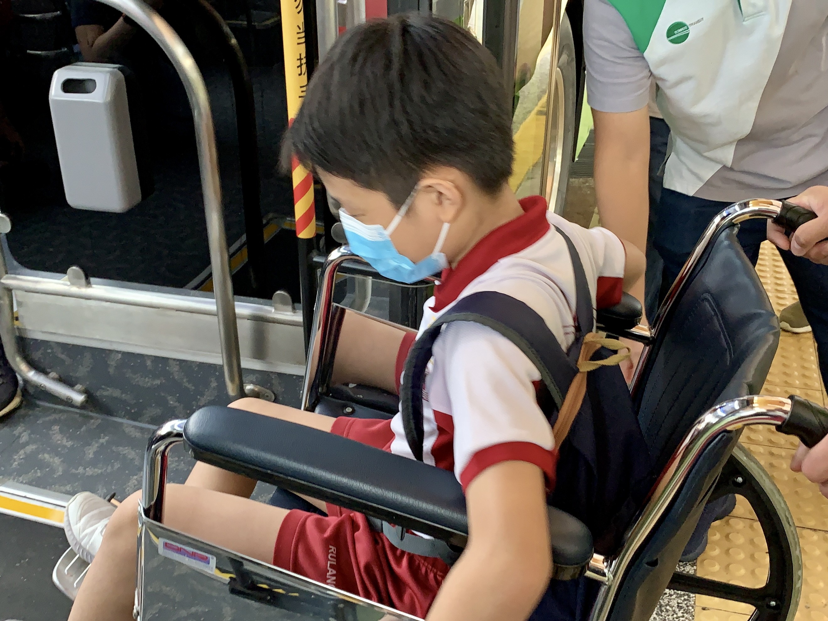 Isaac trying out how to board the bus using a wheelchair