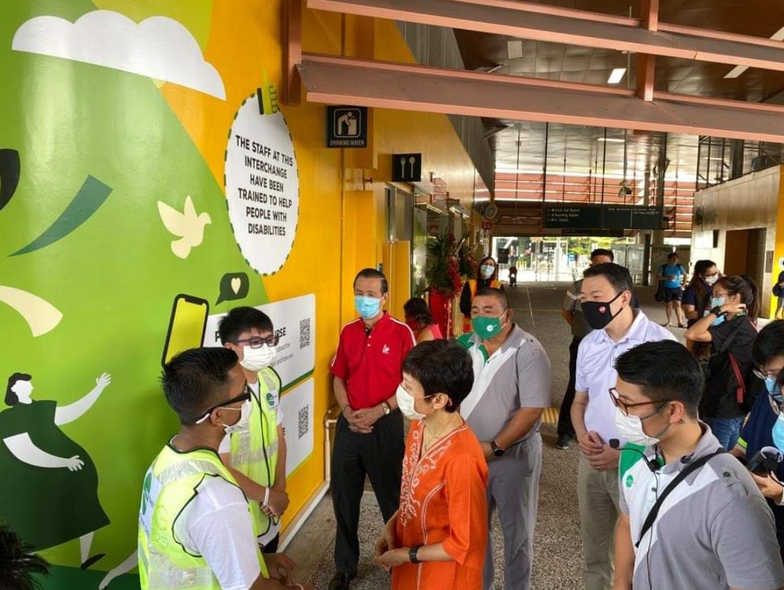 group of people with Keane and another volunteer sharing experiences with Minister Grace Fu