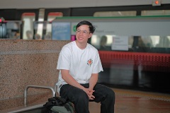 Javier sitting down on bench at Tampines MRT Station platform.)
